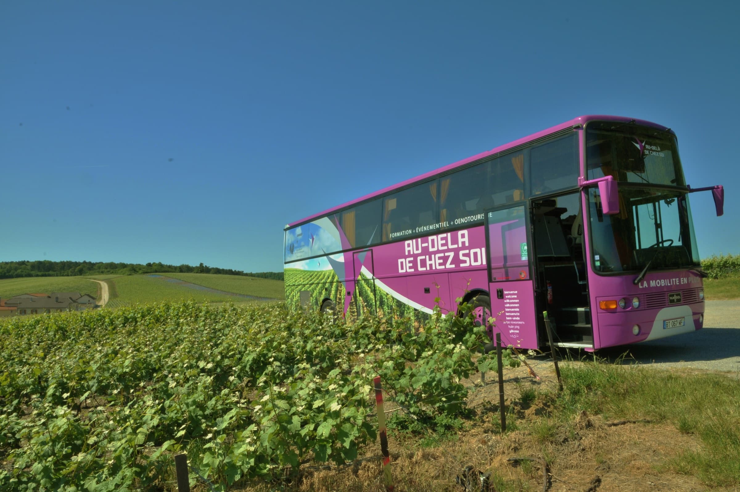 Le bus Au-delà de chez soi garé au bord des vignes
